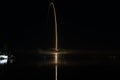 Stunning Rocket Launch: Reflecting off the Water and Through a Cloud