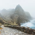 Stunning scenery of the coastal road. Steep black cliffs stretched out ahead, huge waves crashing against steep rocky