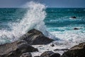 Stunning seascape featuring a powerful wave crashing against a large rock formation at the beach Royalty Free Stock Photo