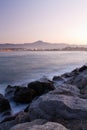 stunning seascape with rocks in satin soft atlantic ocean, mountain trois couronnes at sunset in long exposure Royalty Free Stock Photo