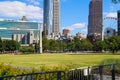 A stunning shot of the buildings and skyscrapers in the cityscape of downtown Atlanta with lush green grass and trees