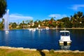 Stunning shot of the deep blue lake water, the lush green plants in the middle of the lake, palm trees and people on the water Royalty Free Stock Photo