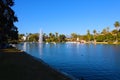 Stunning shot of the deep blue lake water, the lush green plants in the middle of the lake, palm trees and people on the water Royalty Free Stock Photo