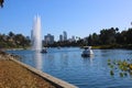 Stunning shot of the deep blue lake water, the lush green plants in the middle of the lake, palm trees and people on the water Royalty Free Stock Photo