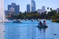 Stunning shot of the deep blue lake water, the lush green plants in the middle of the lake, palm trees and people on the water