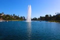 Stunning shot of the deep blue lake water, the lush green plants in the middle of the lake, palm trees and people on the water Royalty Free Stock Photo