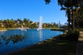 Stunning shot of the deep blue lake water, the lush green plants in the middle of the lake, palm trees and people on the water Royalty Free Stock Photo