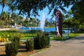 Stunning shot of the deep blue lake water, the lush green plants in the middle of the lake, palm trees and people on the water