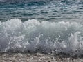 Stunning shot of the dramatic foamy splashing waves on a seashore