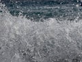 Stunning shot of the dramatic foamy splashing waves on a seashore