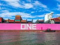 A stunning shot of a large pink container ship sailing down the Savannah River with vast blue river water