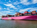 A stunning shot of a large pink container ship sailing down the Savannah River with vast blue river water