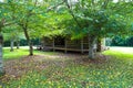 A stunning shot of a majestic log cabin surrounded by brown and yellow fallen autumn leaves Royalty Free Stock Photo