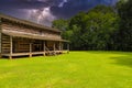 A stunning shot of a majestic log cabin surrounded by brown and yellow fallen autumn leaves Royalty Free Stock Photo