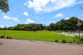 A stunning shot of people with a dog walking across a long stretch of green grass