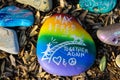 A stunning shot of a rock memorial along a bike path at the beach with colorful rocks and lush green trees