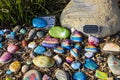 A stunning shot of a rock memorial along a bike path at the beach with colorful rocks and lush green trees