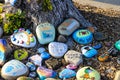 A stunning shot of a rock memorial along a bike path at the beach with colorful rocks and lush green trees