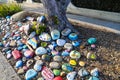 A stunning shot of a rock memorial along a bike path at the beach with colorful rocks and lush green trees