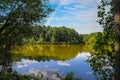 A stunning shot of the silky green lake water of Candler Lake surrounded by lush green trees on the banks of the lake