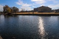 A stunning shot of the still blue lake water surrounded by gorgeous autumn trees in the park with a view of The Parthenon