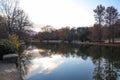 A stunning shot of a still lake in the park surrounded by gorgeous autumn colored trees at sunset at Freedom Park in Charlotte Royalty Free Stock Photo