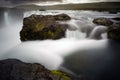 Stunning shot of the water flowing between mossy rocks at Godafoss waterfall, Iceland Royalty Free Stock Photo