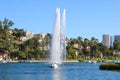 Stunning shot of the waterfall, deep blue lake water, the lush green plants in the, palm trees and people on the water Royalty Free Stock Photo