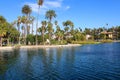 Stunning shot of the waterfall, deep blue lake water, the lush green plants in the, palm trees and people on the water Royalty Free Stock Photo