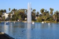 Stunning shot of the waterfall, deep blue lake water, the lush green plants in the, palm trees and people on the water Royalty Free Stock Photo