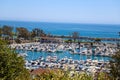 A stunning shot of the white boats and yacht docked and sailing Dana Point Harbor with deep blue ocean water, lush green plants Royalty Free Stock Photo