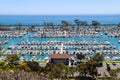 A stunning shot of the white boats and yacht docked and sailing Dana Point Harbor with deep blue ocean water, lush green plants Royalty Free Stock Photo