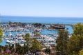 A stunning shot of the white boats and yachts docked and sailing Dana Point Harbor with deep blue ocean water, lush green plants Royalty Free Stock Photo