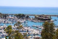 A stunning shot of the white boats and yachts docked and sailing Dana Point Harbor with deep blue ocean water, lush green plants Royalty Free Stock Photo