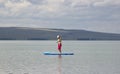 Stunning silhouette of a beautiful girl floating on on the surfboard