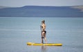 Stunning silhouette of a beautiful girl floating on on the surfboard