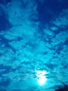 Stunning sky with glowing sun and clouds in blue shades Royalty Free Stock Photo