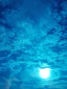 Stunning sky with glowing sun and clouds in blue shades