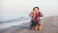 Stunning smiling blond hair hipster woman posing on the beach with her little dog Royalty Free Stock Photo