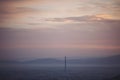 Stunning, soft view of purple blue hour sky above scenic cityscape covered by haze and mist. Royalty Free Stock Photo