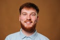 In this stunning studio portrait, a teenage boy with bright red hair shows off