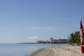 a stunning summer landscape at Crandon Park with blue ocean water, green palm trees and grass, people walking, hotels and condos