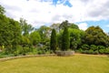 A stunning summer landscape in the garden with with lush green trees, grass and plants and colorful flowers with blue sky Royalty Free Stock Photo