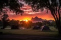 stunning sunrise over a campsite with the silhouette of trees and mountains in the background Royalty Free Stock Photo