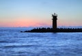 Stunning sunrise over sea with lighthouse.