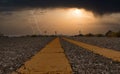 Stunning sunset illuminated by the dramatic lightning over an empty asphalt road Royalty Free Stock Photo