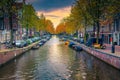 Narrow water canal with boats at sunset in Amsterdam, Netherlands Royalty Free Stock Photo