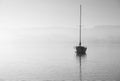 Stunning unplugged fine art landscape image of sailing yacht sitting still in calm lake water in Lake District during peaceful