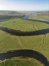 Stunning unusual aerial drone vertical panorama landscape image of meandering river through marshland at sunrise