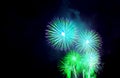 Vibrant blue and green fireworks exploding in to the night sky Royalty Free Stock Photo